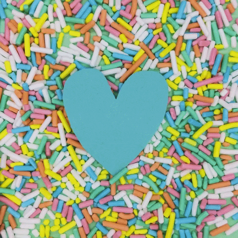 A heart alternating colors on a background of multi-colored sprinkles