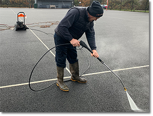 Image of operative power washing sport courts