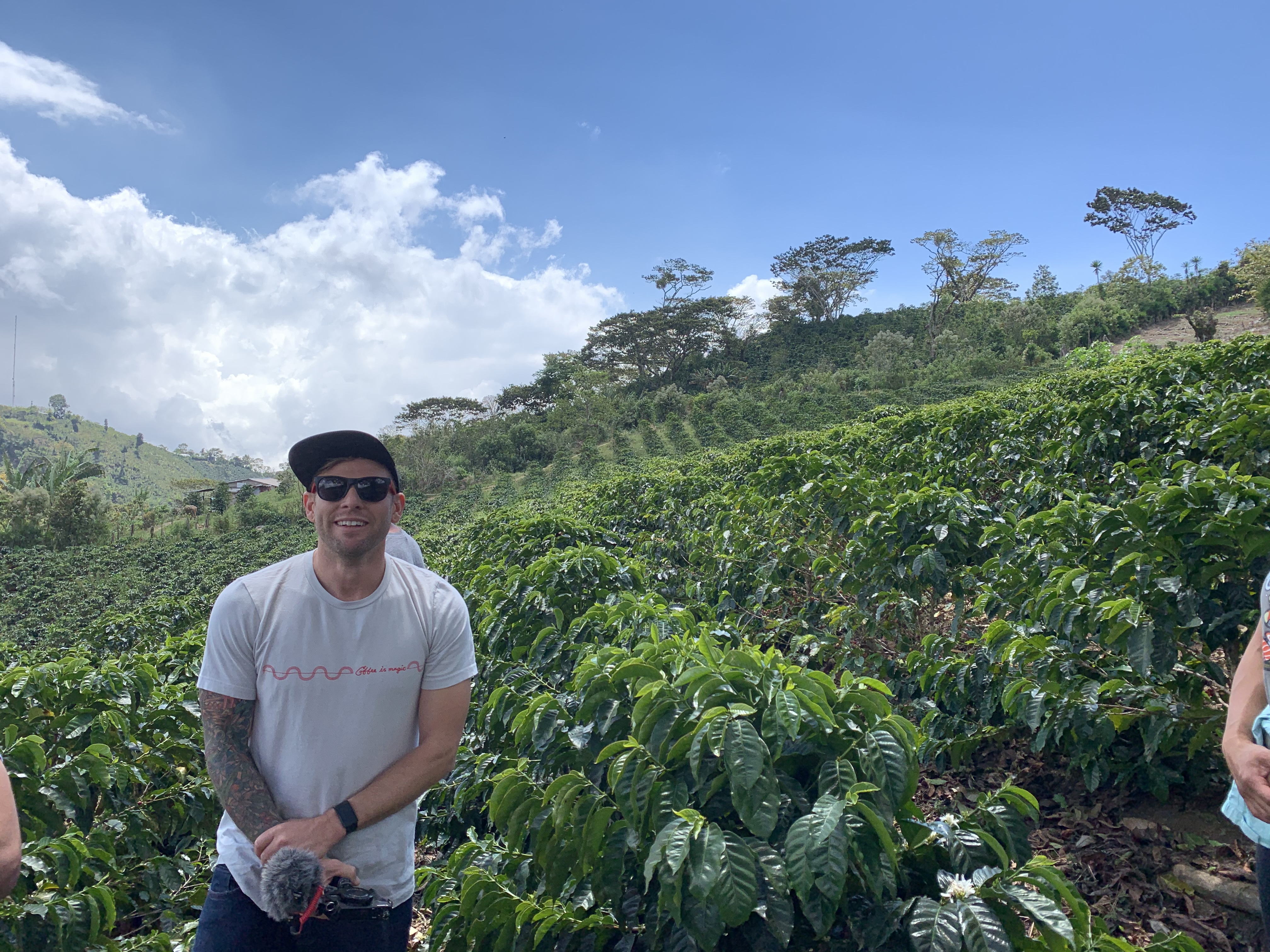 Jared Truby posting in front of coffee field.