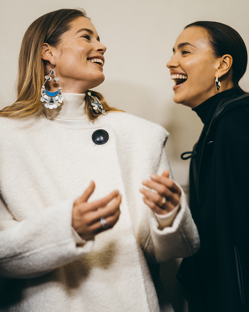 the models are laughing and wearing the Gelton coat and Eowyn cape from the FW20 collection
