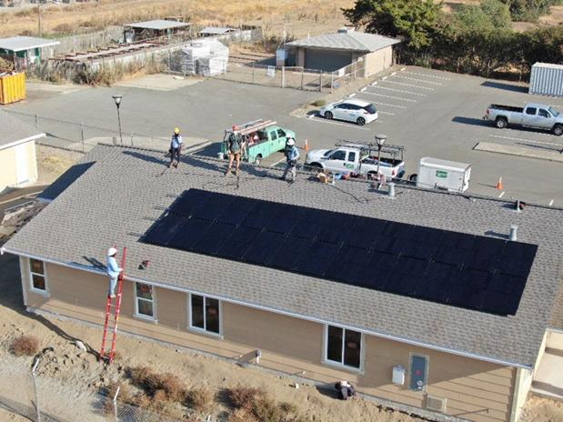 IMG: GRID construction crew on a roof with solar panels