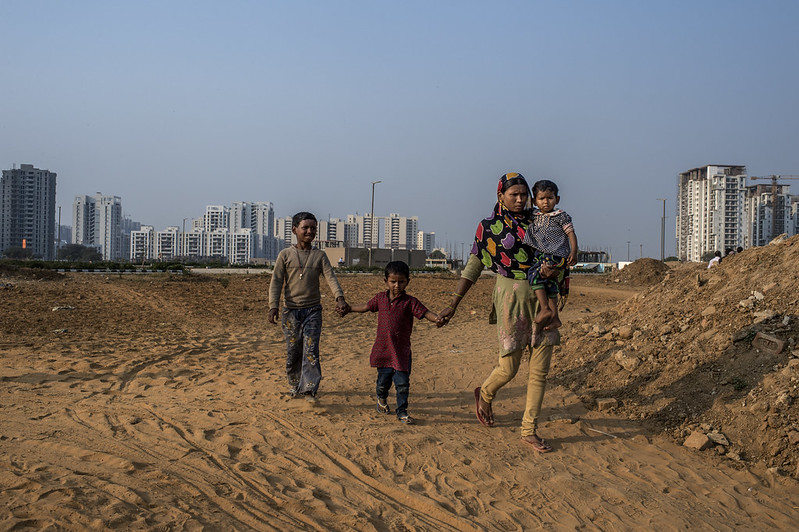 An Indian internal migrant walks with her children in Delhi.