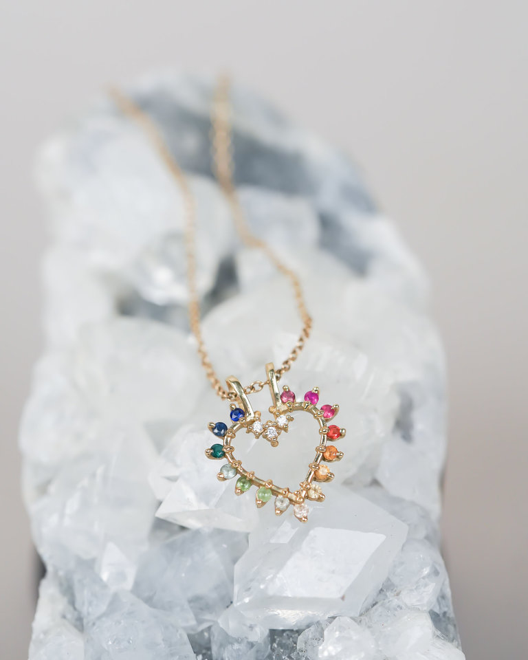 A crystal sets the scene and holds a rainbow sapphire heart necklace.