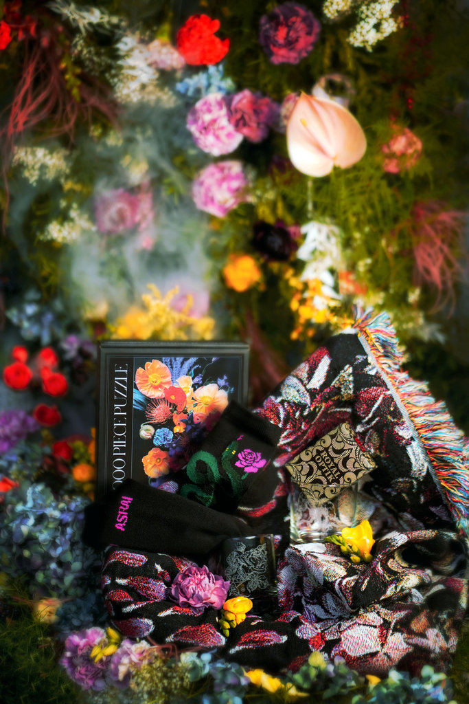 A bright floral forest sets the backdrop for an Asrai Garden puzzle, socks, uusi playing cards, set of two glass rocks glasses and gorgeous floral print blanket.