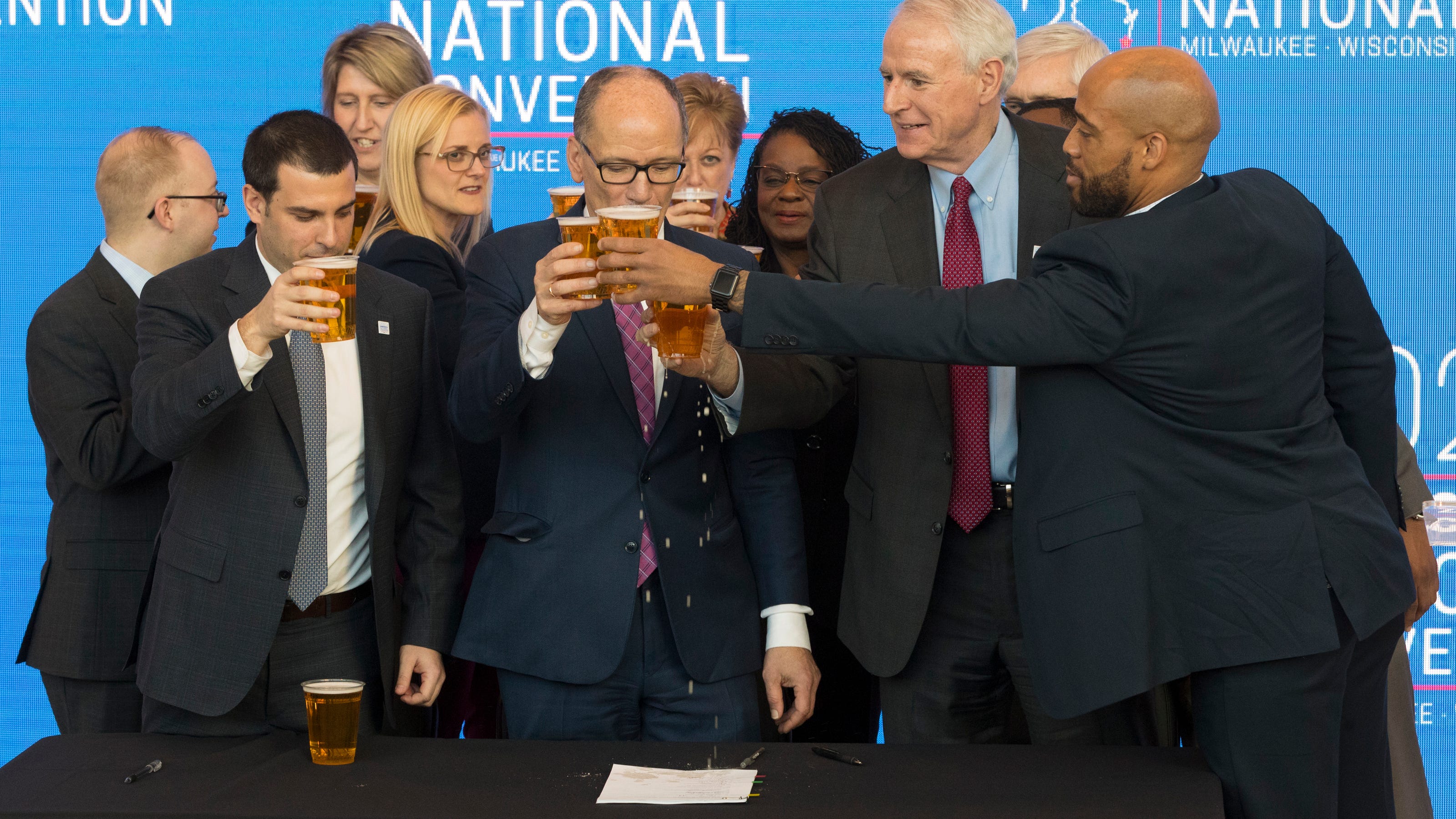 Democratic National Committee Chairman Tom Perez (center) reacts after spilling a celebratory beer on the convention contract with Milwaukee Bucks Senior Vice President Alex Lasry (left), Milwaukee Mayor Tom Barrett and Lt.  Gov. Mandela Barnes following the official announcement that Milwaukee will host the 2020 Democratic National Convention at Fiserv Forum on Monday. Milwaukee snagged the event over Houston and Miami.