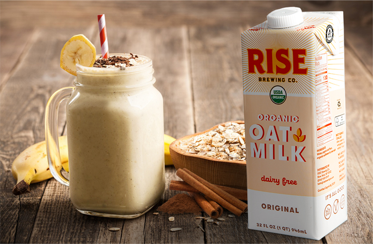 Photo of Rise organic oat milk, and a glass, a banana, oats and cinnamon. 