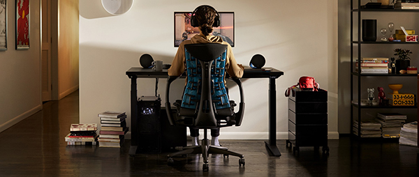 A person sits in an ergonomic gaming set up