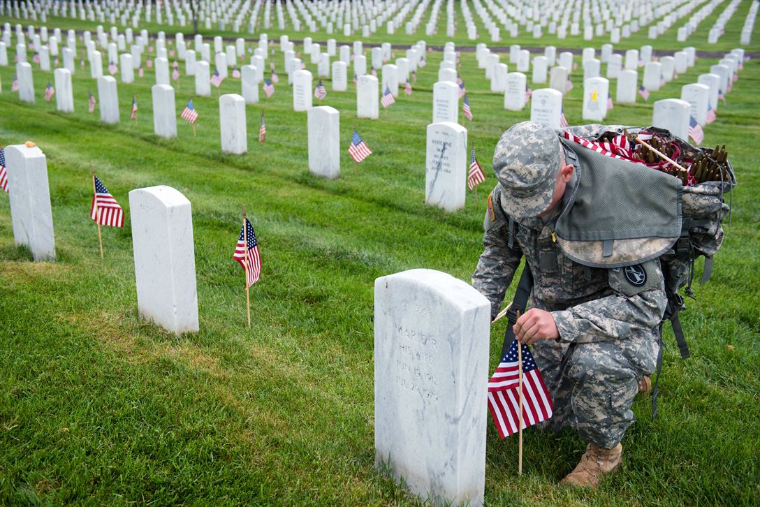 Soldier puts a flag down in Arlington Cemetery in Virginia.