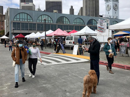 Vendor stalls are situated farther apart to encourage social distancing during the coronavirus pandemic at the Ferry Plaza Farmers Market in San Francisco. Lila LaHood / Public Press