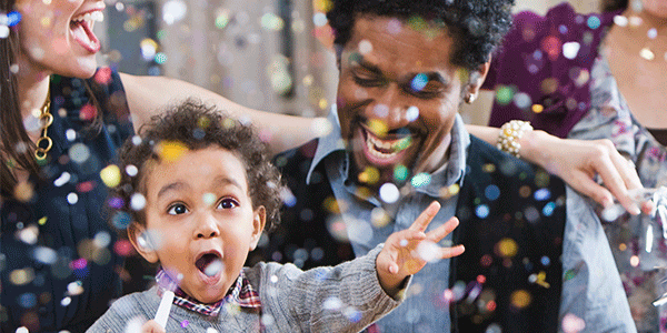 Happy family smiling while confetti falls