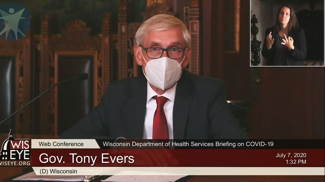 Gov. Tony Evers wears a face mask during a briefing with reporters on the state's response to the coronavirus pandemic.