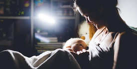 Woman holds infant in the dark - Image