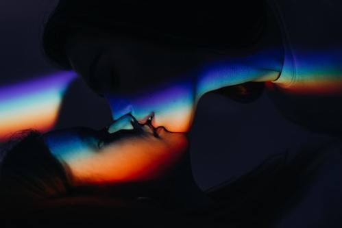 Rainbow shadow casted on two people kissing