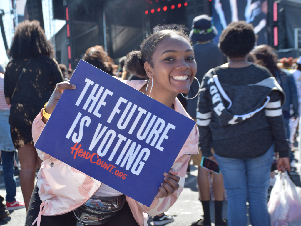 Person holding The Future Is Voting sign.