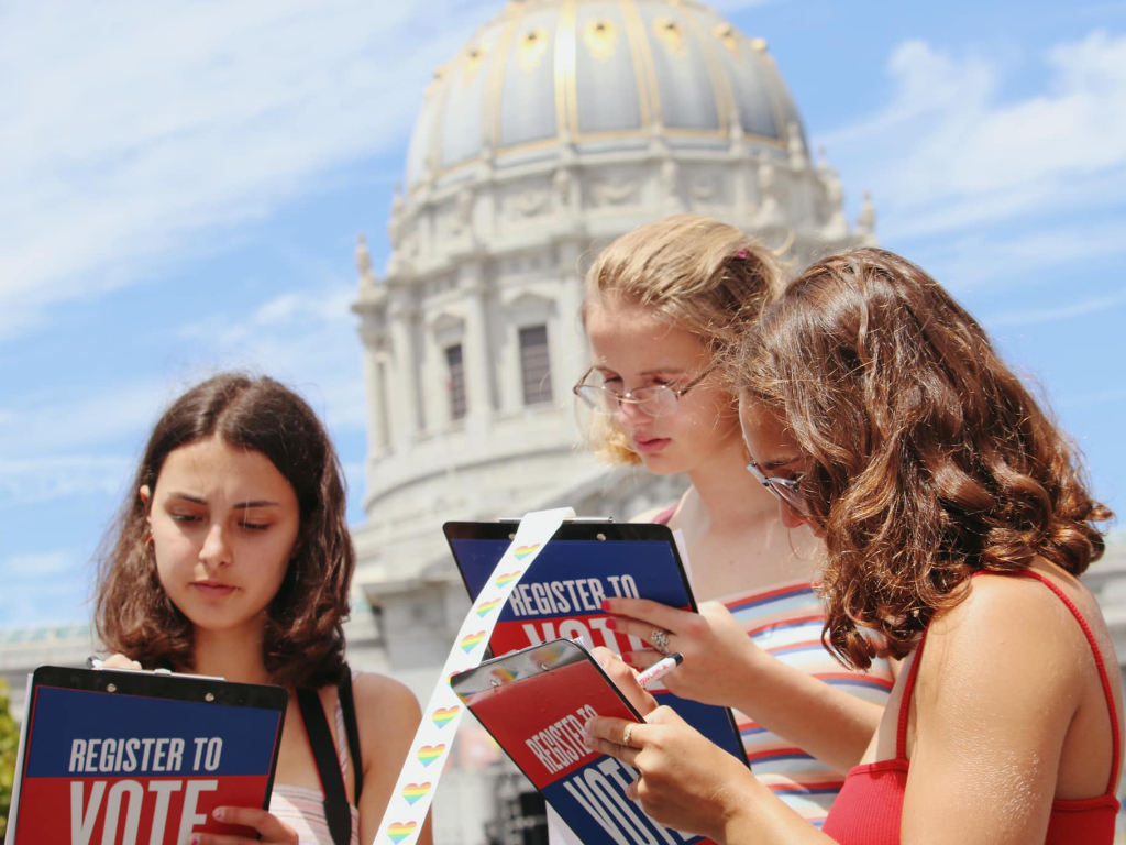 Three people registering to vote.