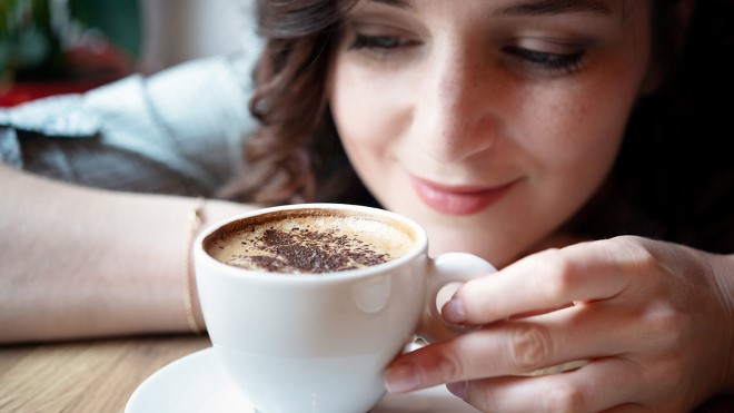 Woman looking closely at coffee cup