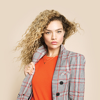 Curly-haired woman in plaid blazer
