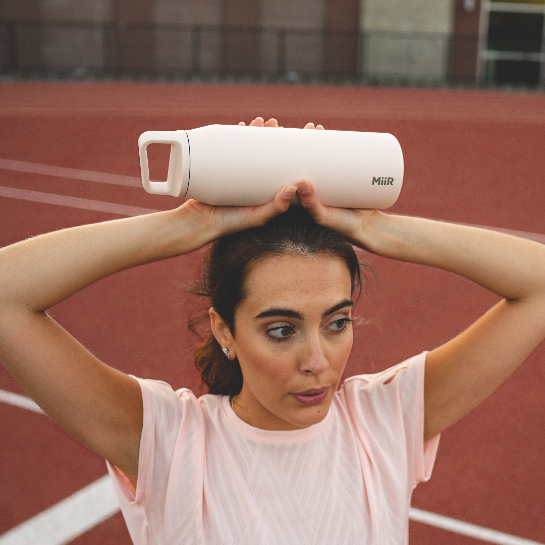 Person holding 32oz Wide Mouth Bottle in Thousand Hills on a running track.