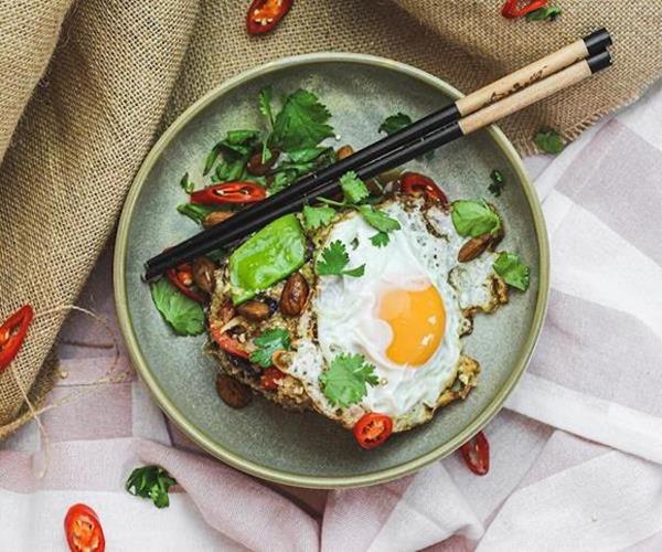 Nourished bowl with egg and chopsticks.