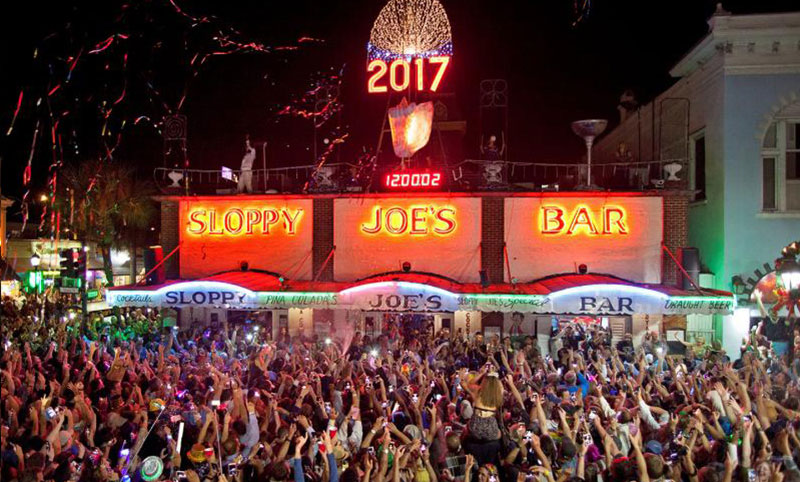 Main banner image depicts a large party taking take in New Years Eve outside a Sloppy Joe Restaurant