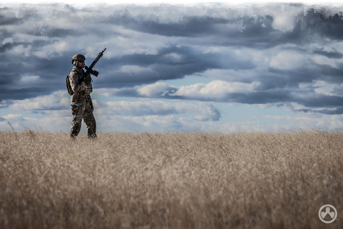 Man with firearm standing in field