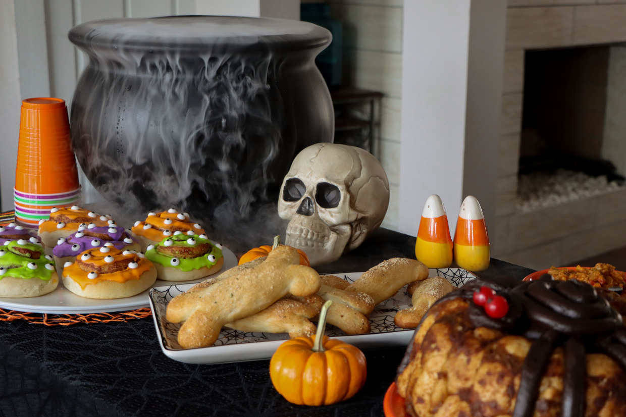 Halloween party table with Rhodes Monster Cinnamon Rolls, Bone Chillin'' Breadsticks and a Spider on a Bundt.