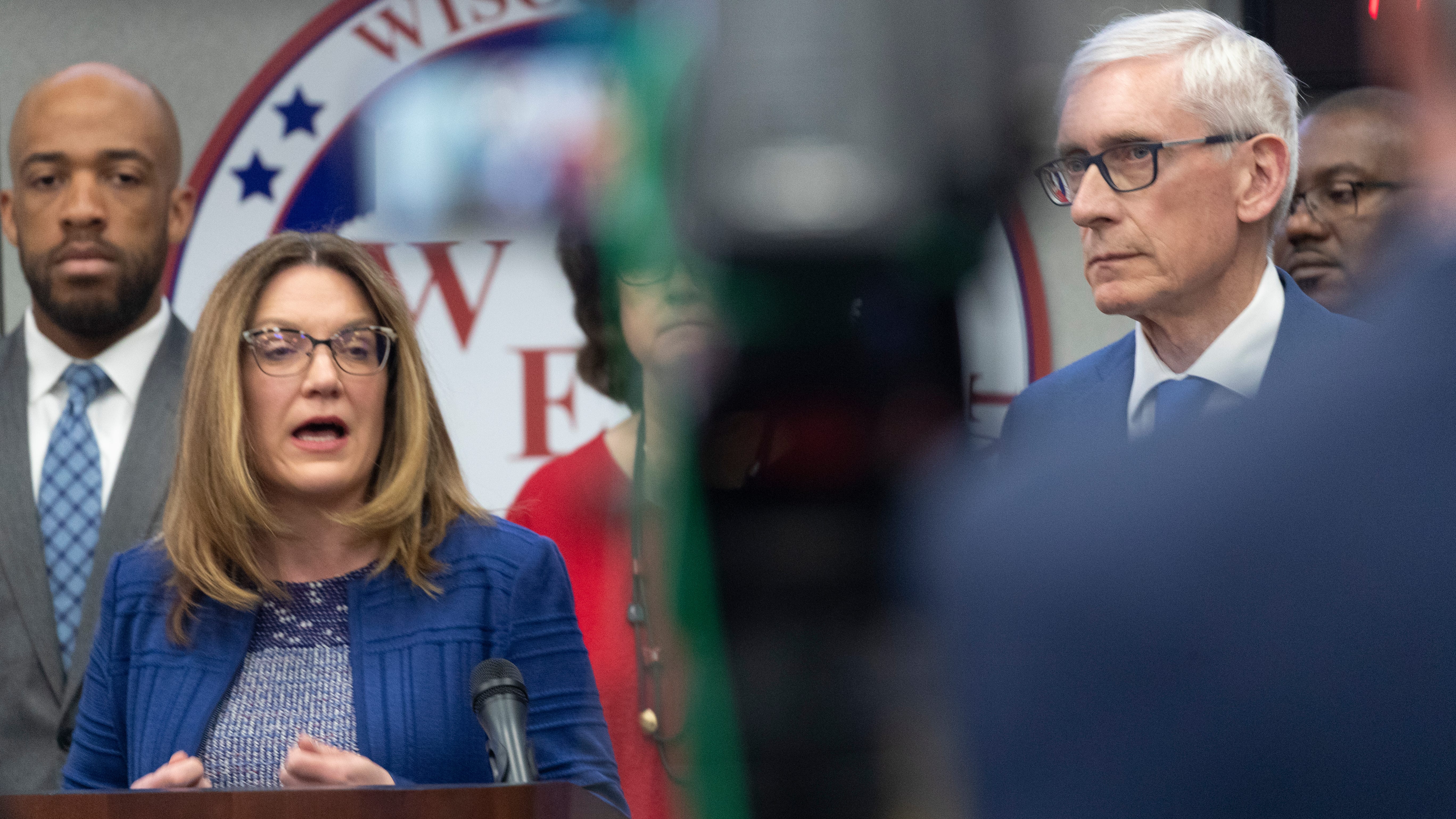 Wisconsin Department of Health Services (DHS) Secretary  Andrea Palm, left,  speaks as Gov. Tony Evers looks on at a briefing to discuss updates to the state's response to the coronavirus pandemic.