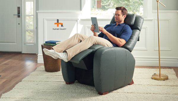 image of a woman in a recliner and a man over looking a tablet in hand