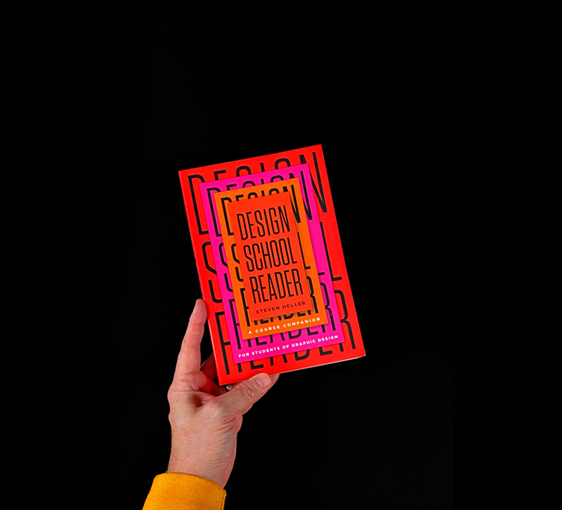 Hand holding book with red, pink, and orange cover with black and white type