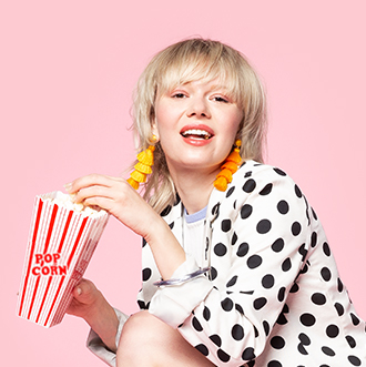 Woman eating popcorn in polka dot jacket