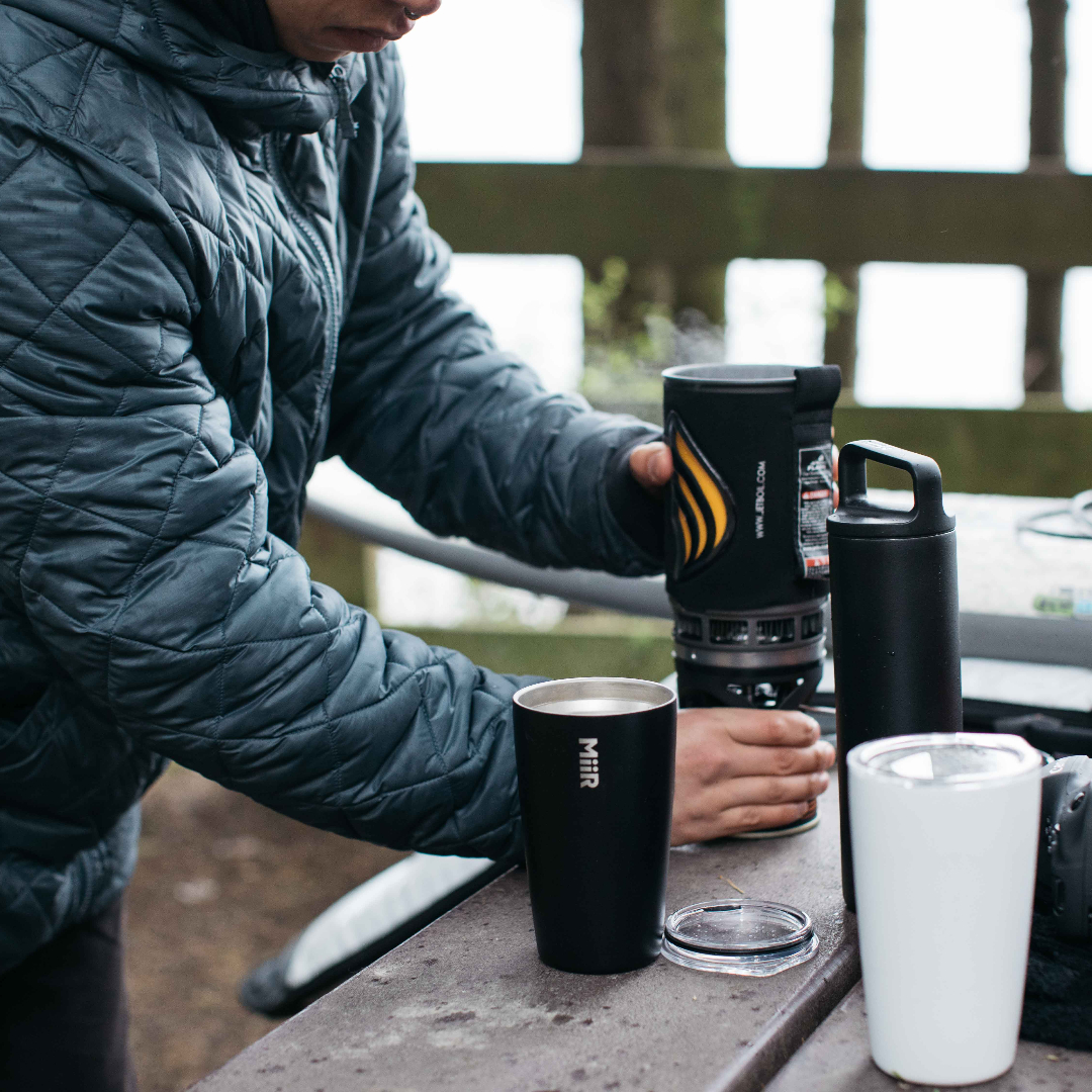 Person with Tumblers at table.