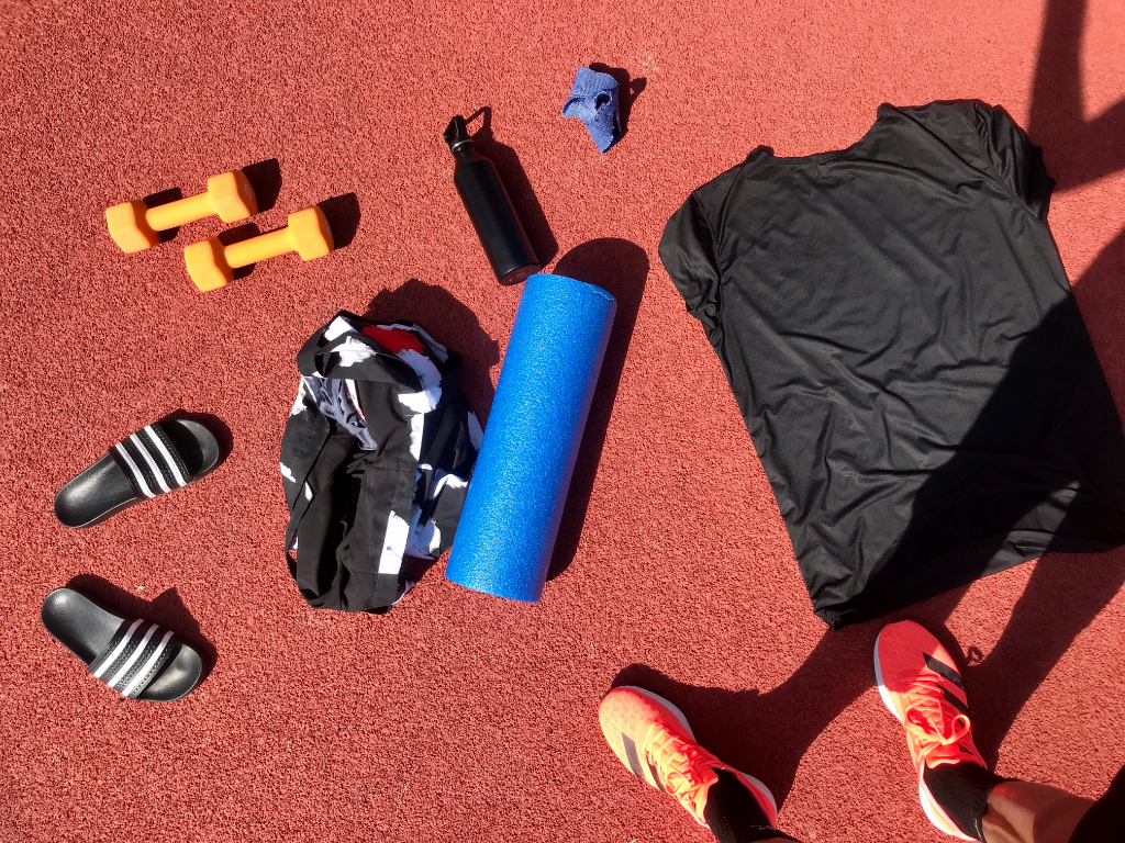 27oz Bottle in Black next to running gear on track.