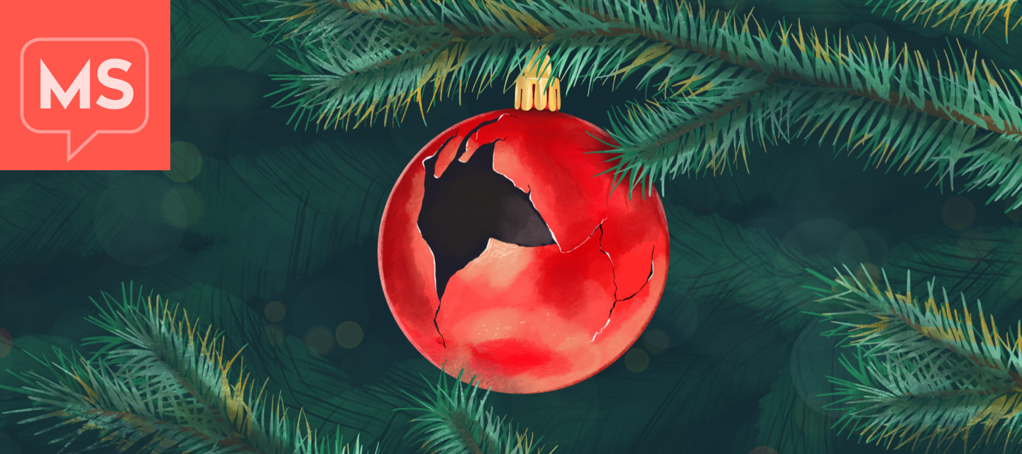 A broken holiday ornament hanging on a tree