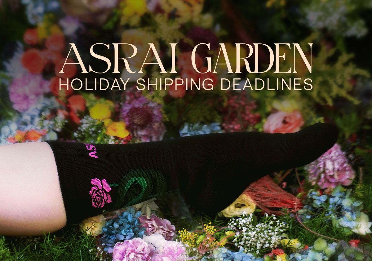 A floral forest floor creates a backdrop for a foot with a black Asrai sock on. The text says; Asrai Garden Holiday Shipping Deadlines 