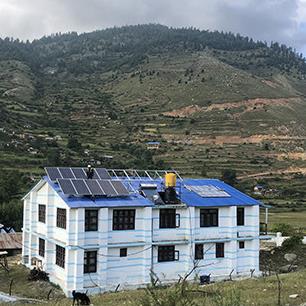 The health clinic, with mountains in the background, with solar on the roof