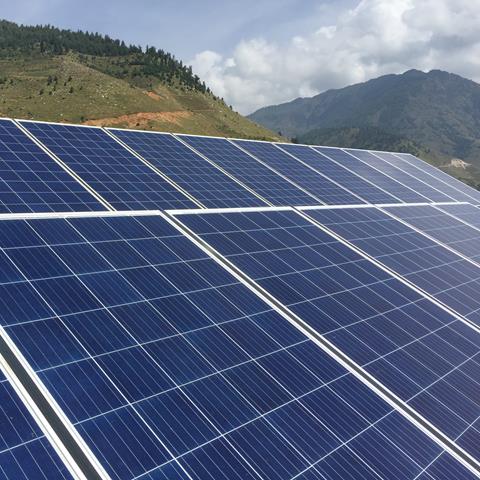 A solar array, with Nepal mountains in the background