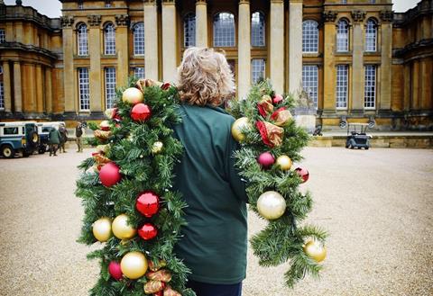 Lady carrying Christmas decorations towards the entrance of The Palace