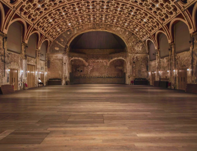 An empty Grand Hall with Duty Manager Maureen Martin sat on a chair