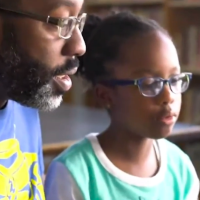 A father helps his daughter with her homework