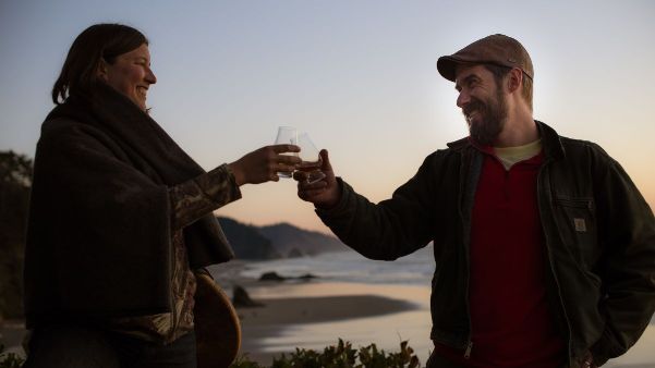 Val and Geoff of Walnut Studiolo Toasting Whiskey on the Oregon Coast