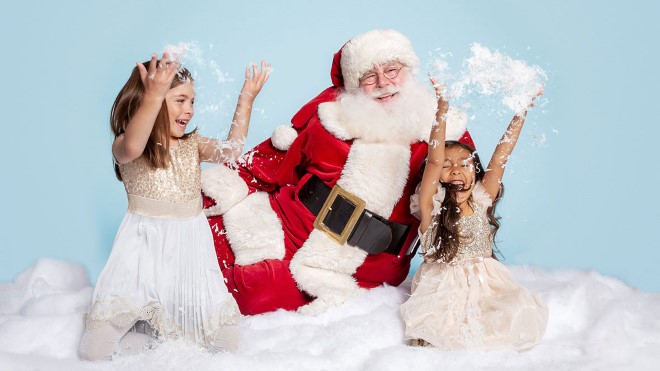 Santa with two little girls throwing snow