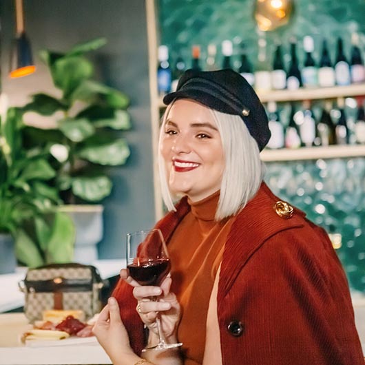 Accessorized blonde woman with glass of wine