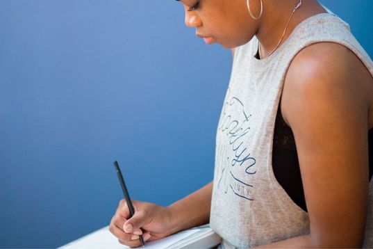 African American woman with pen and pad, writing