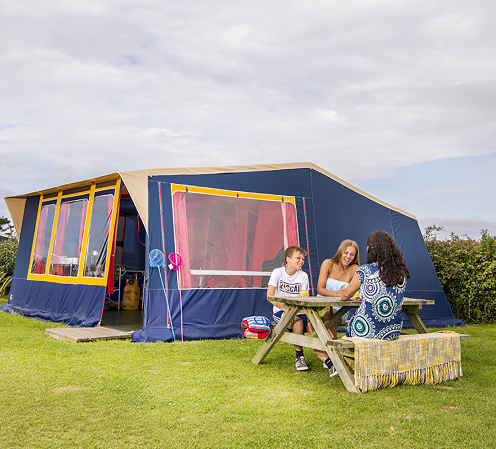 A family sat outside a ready tent at Trevornick Holiday Park in Cornwall