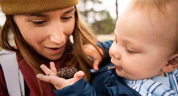 image: mother and baby holding pine cone from The North Face