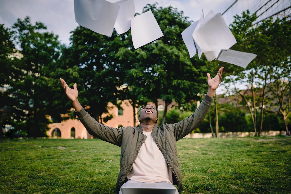 excited-male-student-throwing-university-papers-in-air-4560148