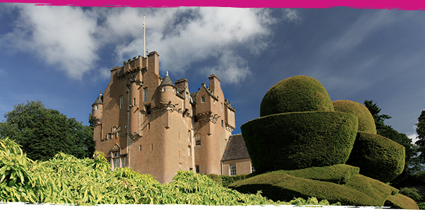 Crathes Castle surrounded by trees and clipped hedges