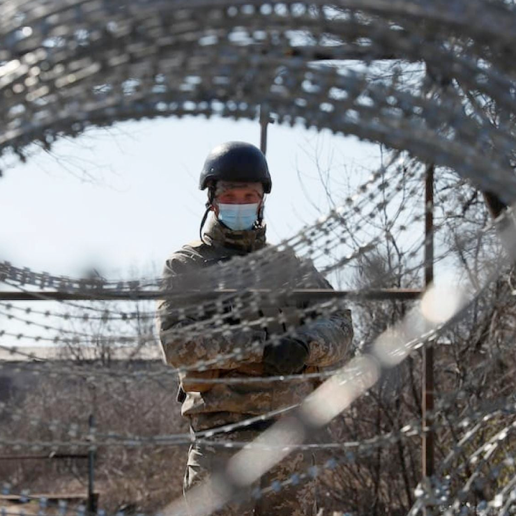 Image of soldier behind barbed wire