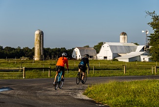 bicyclists passing a farm