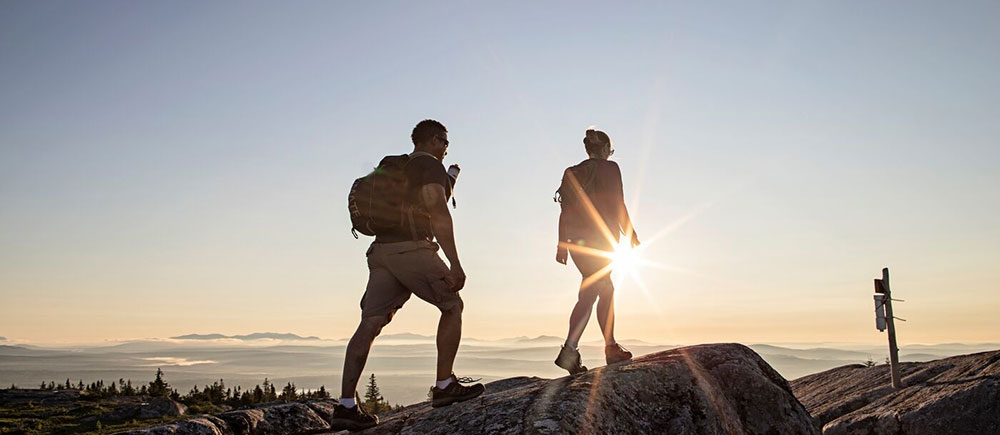 Two hikers with the sunset walking on protected public lands.
